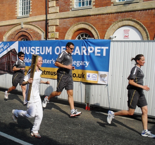 The Olympic torch is carried past the Museum of Carpet, 24 May 2012